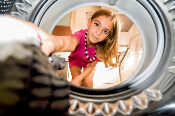 Ung Flicka Visar Lycka När Hon Lägger Sina Kläder Tvättmaskinen Stockbild