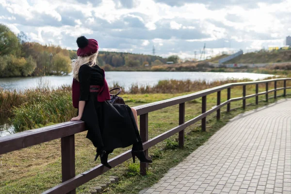 青い空を背景に黒い服を着た優しい唇をした大人の少女が立ち並ぶ. — ストック写真