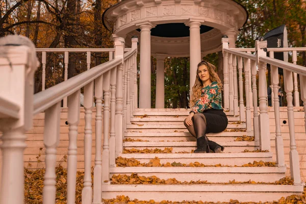 Ein schöner Jüngling steht da, ein Erwachsener mit charismatischem Aussehen, eine Blondine im farbigen Hemd, stehend, vor dem Hintergrund der Schritte Humor Herbstglanz Umarmung — Stockfoto