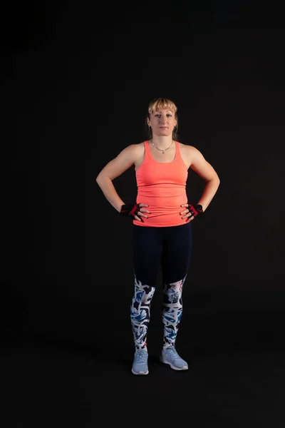 Fitness Girl auf einer Trittplattform mit einer Langhantel mit Kurzhanteln. Sport treiben auf schwarzem Hintergrund Heiter mit schönen Augen — Stockfoto