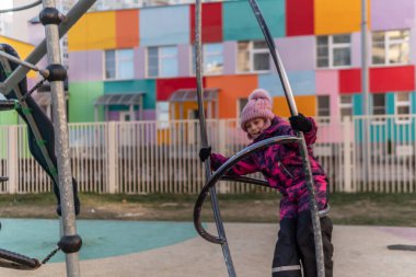 Çocuk simülatörde oyun oynuyor, eğlence merkezinde bir sonbahar ceketi ve bir şapka var, neşeli..