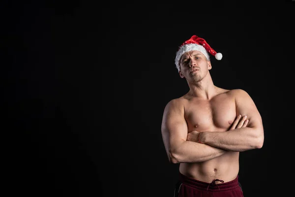 Noel Baba. Siyah bir arka planda genç, yakışıklı, çekici ve zarif. Kırmızı şapkalı, Noel tatillerinde, yumuşak dudaklı..