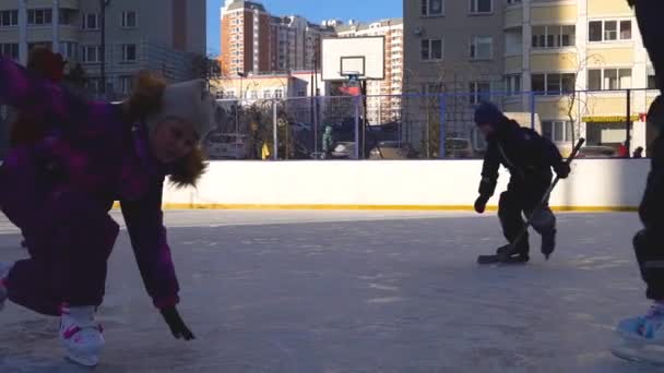 Children skate in a box with white skin on ice in winter. RUSSIA, MOSCOW - DEC 12, 2020 — Stock Video