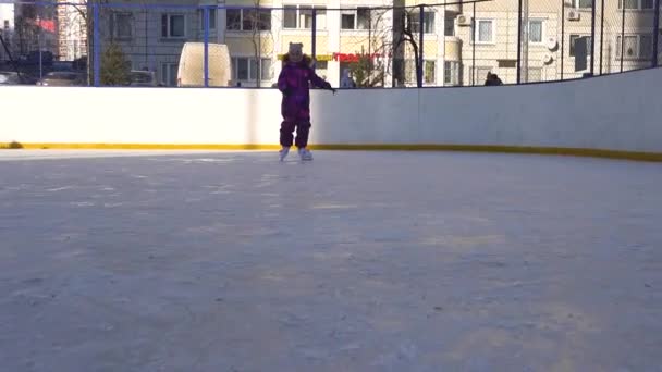 Girls skate near houses, with white skin on ice in winter. RUSSIA, MOSCOW - DEC 12, 2020 — ストック動画