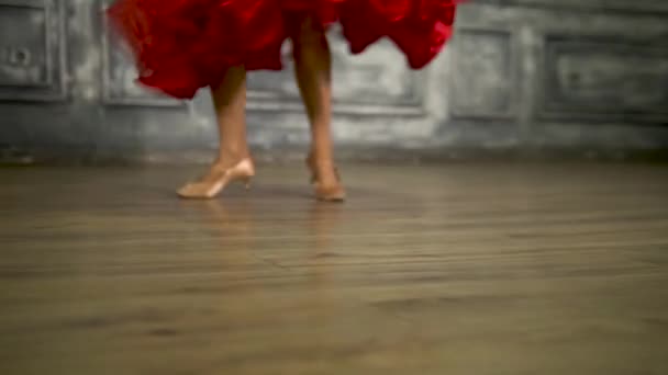A táncosok lábai piros ruhában. Pörgés, keringőzés — Stock videók