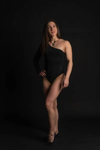 Fitness žena tělocvična černá. V černých plavkách. Usmívající se holeně, ženy zdravý životní styl. , trup. Stojí za to — Stock fotografie