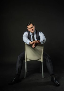 Üç parçalı takım elbise içinde bir sandalyede genç adam üç parçalı takım elbise iş adamı akıllı, sıradan bir portre. Satış elemanı memnuniyeti, başarı yalnızlık geçmişi siyah vücut geliştirici