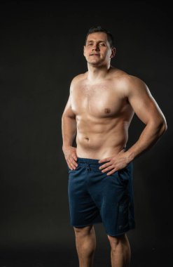 Eller erkeğin kemerinde. Çıplak gövde seksi bir erkek, genç bir mutluluk çocuğu, modaya uygun havalı bir arka plan siyahi vücut geliştirici.