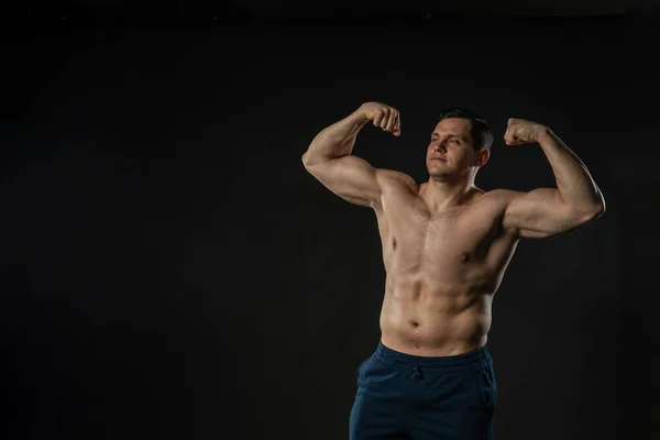 Mans bicepsz mutatja csupasz törzs Fiatal férfi férfi férfi, modern tartalom eladó, súlyzó egyetlen háttér fekete testépítő — Stock Fotó