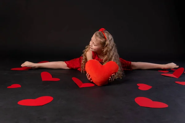 Kalp kağıdının ellerindeki sicimde kalpler kırmızıyı sever, sevgililer günü, yerde yatan kalpler güzeldir. İlham pankartı. Şenlikli bir gün, kırmızı elbiseli bir kızın mutluluğu, yalınayak