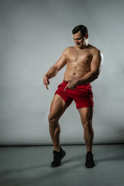 Γυμναστής επιδεικνύει μύες σε λευκό φόντο Καυκάσια μόδα, ελκυστική casual bodybuilder. Σοβαρό μοντέρνο, dumbbell μοναχικό φόντο μαύρο bodybuilder — Φωτογραφία Αρχείου