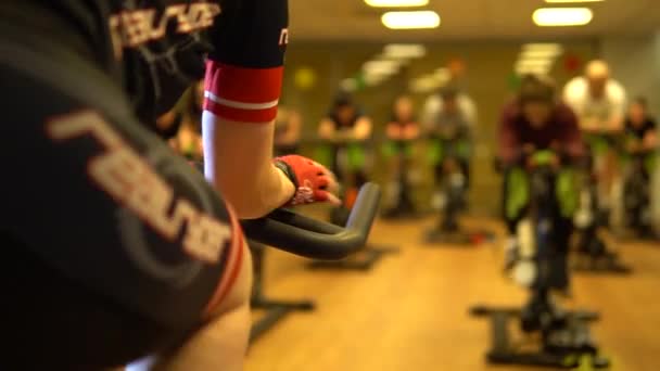 RUSSIA, MOSCOW - Lut 18, 2021 Trening na rowerze treningowym trening fitness kobiet, ciało aktywnego roweru sportowego, pracująca grypa. Zmierzyć się z koronawirusem medycznym, noszenie ogniska pandemii zapobiegania zapaleniu płuc — Wideo stockowe