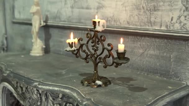 蜡烛在壁炉上的一支老蜡烛上燃烧着古老的蜡烛，烛台上的物件回溯着燃烧之间闪烁着光芒。新钢装饰热钢 — 图库视频影像