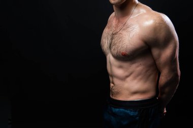 Siyah arka plandaki adam spor, vücut ağırlığı spor, ağır ve sağlıklı yaşam tarzında halterleri şişirmeye devam ediyor. Genç tenli.