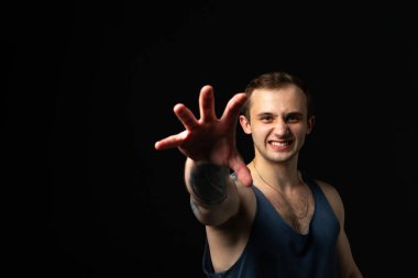 Siyah arka plandaki adam fitness vücut geliştirme kaslarını şişirmeye devam ediyor. Göğüs kaslarını sıkı tutuyor. Çekici spor gücü, tek formda.