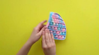 Çocuklar için anti-stres oyuncağı sarı arka planda çocuk oyuncağı siyahi Fijit 'te çocuk üst görünümü basit gamzeli popit eğlenceli çocuklar, rahatlama pop popüler rt, modern Hand duyusal ceza