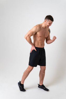 Beyaz arka planda bir adamın kalçasını acıtmak. Güçlü, ağrılı, hasta, erkek, sağlıklı bir yetişkin, el ifadesi. Bel ağrısı çekicidir.