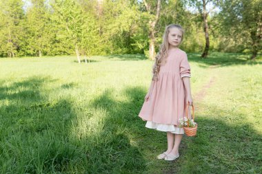 Bir kız güzel beyaz bir elma ağacını kokluyor. Elma ağacının çiçek açmasının ortasında güzel bir kız mutlu bir yüz ifadesi takınıyor. Yazlık kadın, model beyaz. Çekici güzel kadın.