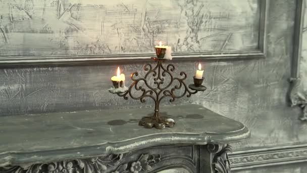 Burning candle in an old candle on the fireplace candelabra fire, flames traditional burn wax decoration, bronze Age to beeswax, decor hot steel — Stock Video