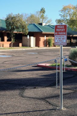 Phoenix, AZ - 5 Aralık 2025: Park sınırlaması olmayan özel bir mülkten araç çekmekle ilgili kırmızı-beyaz uyarı levhası.