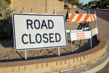 Phoenix, AZ - 12 Aralık 2025: Parlak beyaz dikdörtgen şekilli Yol Kapama İşareti ve turuncu-beyaz barikatlar Phoenix kış maratonunun hemen önünde yaya kaldırımının kenarında kuruldu 