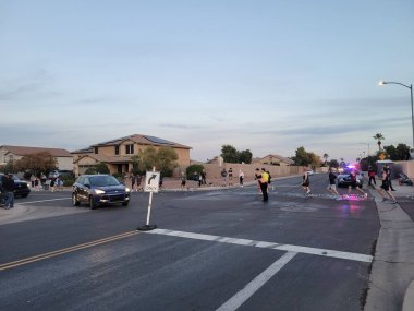 Phoenix, AZ - 13 Aralık 2025: Phoenix kış maratonu sırasında Paradise Lane 'de ve 39. Cadde' de sarı yelekli bir polis merkezi doğrudan araba trafiği
