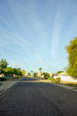 Güneşli bir kış sabahı, parlak mavi gökyüzü ve bazı beyaz ışık bulutları güneybatı Amerika 'nın Phoenix, Arizona şehrinde sakin bir yerleşim bölgesinde.