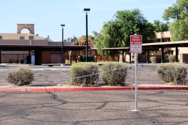 Kısıtlı bir otoparkta araç çekmekle ilgili kırmızı-beyaz uyarı yazan zincir bariyeri.