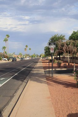 Phoenix, AZ - 1 Haziran 2025: Park sınırlaması olmayan ayrılmış bisiklet yolu yerleşim yeri Phoenix, Arizona caddesi boyunca geniş beyaz bir çizgi ile ana yoldan ayrıldı.