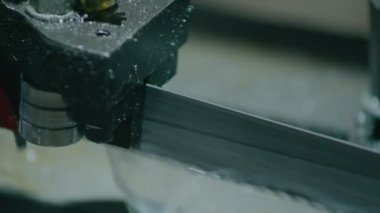 Ağır endüstri, elektrikli testereli bir makine metal çubukları daha fazla parça üretmek için kesiyor.