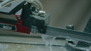 Ağır endüstri, elektrikli testereli bir makine metal çubukları daha fazla parça üretmek için kesiyor.