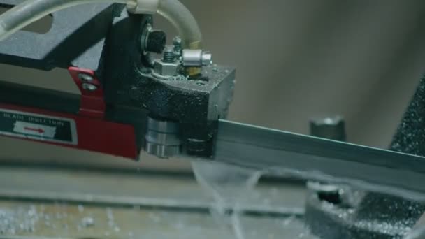Zware industrie, een machine met een elektrische zaag snijdt metalen staven voor de verdere productie van onderdelen uit hen — Stockvideo
