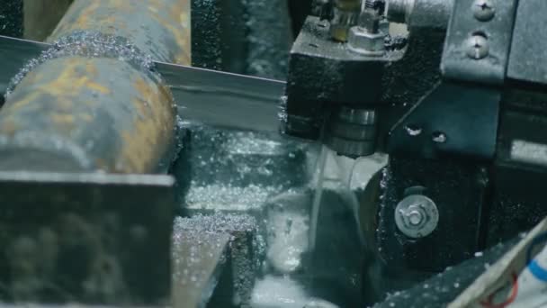 톱을 사용하는 기계인 중공업은 그것으로부터 부품을 더 생산하기 위해 금속 막대를 잘라 낸다 — 비디오