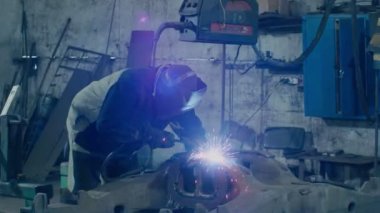 Ağır sanayi, kaynakçı araba tamiri için metal parçaları kaynaklıyor