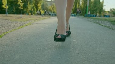 Spor ayakkabılı bir kadının bacakları kırsalda ya da çayırda yürürken..