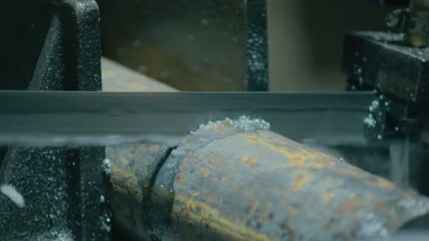톱을 사용하는 기계인 중공업은 그것으로부터 부품을 더 생산하기 위해 금속 막대를 잘라 낸다 — 비디오