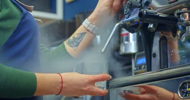 一个戴着防护口罩的女孩在一家有蒸汽的咖啡店里洗了一杯咖啡 — 图库视频影像