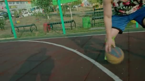 Kryvyi Rih Ucrania - 01.05.2021 chico atleta de entrenamiento con un baloncesto en el patio de recreo lento mo 4k 100fps — Vídeos de Stock