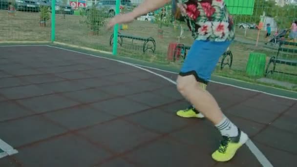 Kryvyi Rih Ukraina - 01.05.2021 kille idrottare utbildning med en basket på lekplatsen slow mo 4k 100fps — Stockvideo
