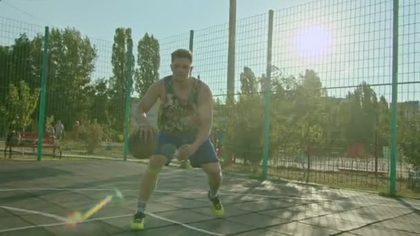 Kryvyi Rih Ucrania - 01.05.2021 chico atleta de entrenamiento con un baloncesto en el patio de recreo lento mo 4k 100fps — Vídeos de Stock