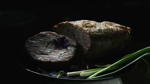 Vlees met uien op een zwarte bord presentatie, spelen met licht — Stockvideo