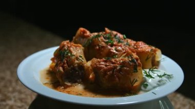 Parçalanmış et güveci lahana yaprakları şeklinde ve tabakta, ışıkla oynayın, yemeğin sunumunu yapın.