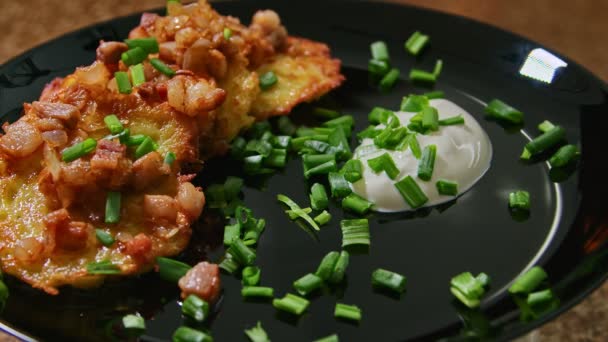 Frittelle, piatto di patate grattugiato, piatto bielorusso, con panna acida ed erbe aromatiche, presentazione del piatto — Video Stock