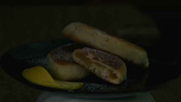Бабушкины пироги с яблоком на черной тарелке, презентация блюда — стоковое видео