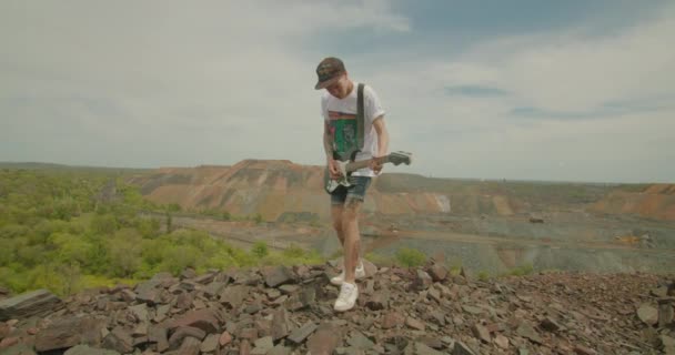 Kryvyi Rih, Ukraine - 05.23.2021 the guitar arist of the rock band plays in the industrial zone, iron ore dump ProRes 422 slow mo, bmpcc4k — 图库视频影像