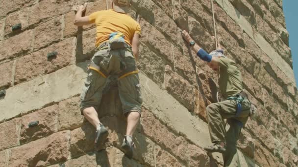 Kryvyi Rih, Ukraina - 05.23.2021 alpinista wspina się na kamienny stojak, kolumna starego mostu, stary hokej wspinaczkowy ProRes 422, bmpc4k — Wideo stockowe