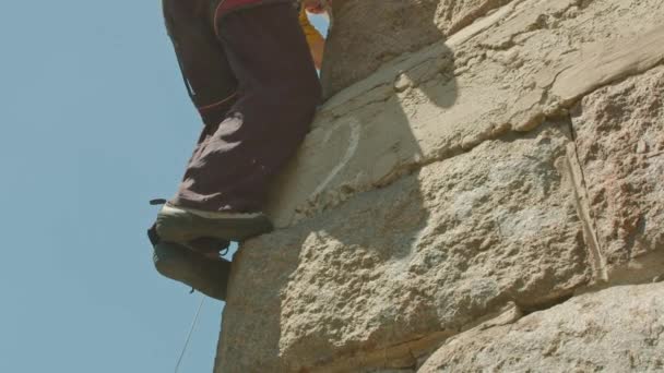 Kryvyi Rih, Ukraine - 23.05.2021 ein Bergsteiger erklimmt einen Steinstand, eine Säule einer alten Brücke, ein alter Bergsteiger Hockey ProRes 422, bmpcc4k — Stockvideo