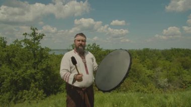 Schuman bir adam şamanik bir davul çalar, yağmur yağdırmaya çalışır, eski tanrılara ve doğaya tapar. Şamanın doğadaki anlamı, prores 422, bmpc4k