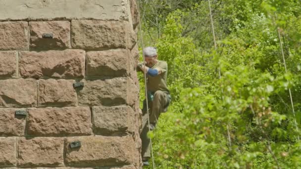 Kryvyi Rih, Ukrayna - 05.23.2021 Bir kaya tırmanıcısı eski bir köprünün bir sütunu, eski bir dağcı hokey proRes 422, bmpc4k — Stok video