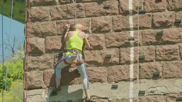 Kryvyi Rih, Ucrânia - 05.23.2021 um escalador de rocha sobe um suporte de pedra, uma coluna de uma ponte velha, um velho hóquei de alpinistas ProRes 422, bmpcc4k — Vídeo de Stock